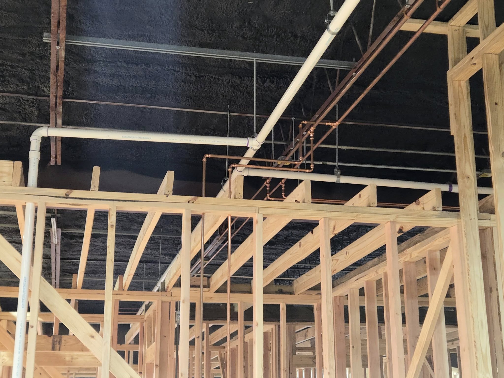 Ceiling plumbing connections with copper water lines and PVC drain pipe